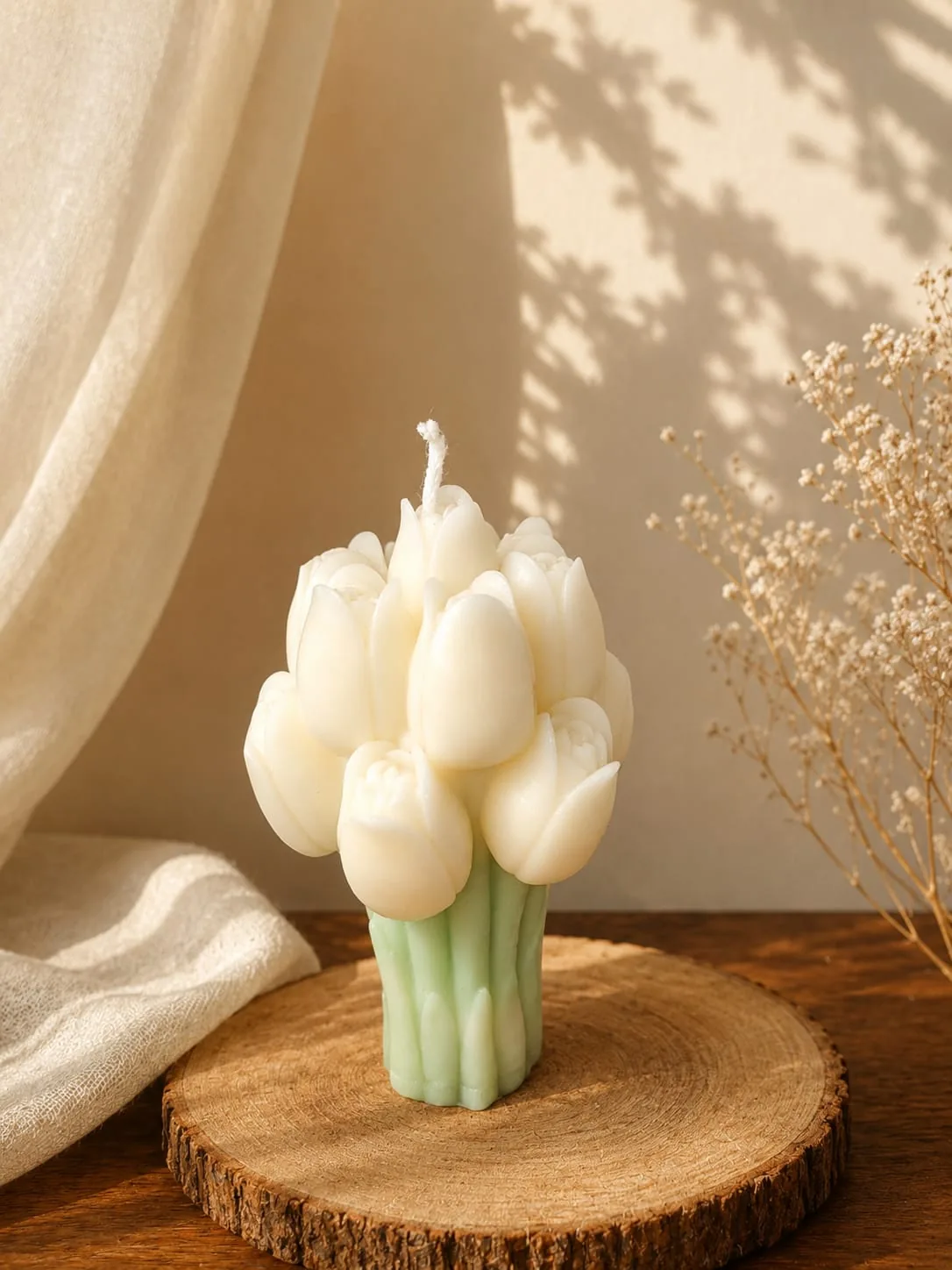 Cream tulip bouquet candle standing on a round wooden board